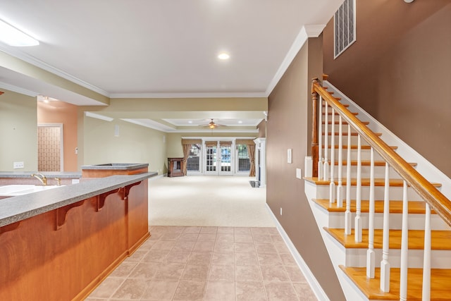 interior space with ceiling fan, sink, light carpet, and ornamental molding