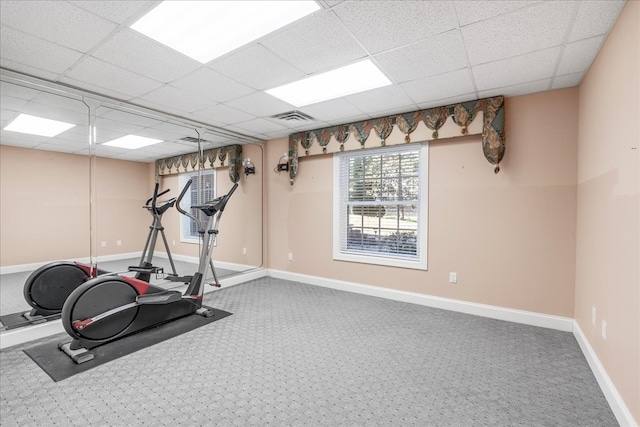 workout room with a paneled ceiling and carpet