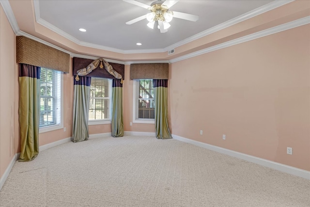 empty room with ornamental molding, a raised ceiling, ceiling fan, and carpet flooring