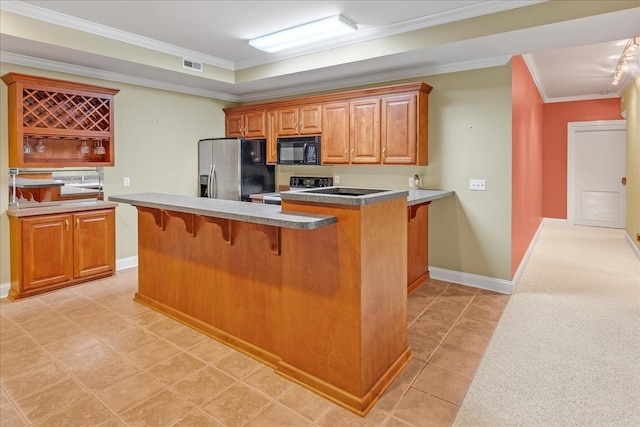 kitchen with black microwave, a breakfast bar area, visible vents, stainless steel refrigerator with ice dispenser, and range