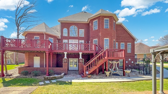 exterior space featuring a wooden deck, a yard, and french doors