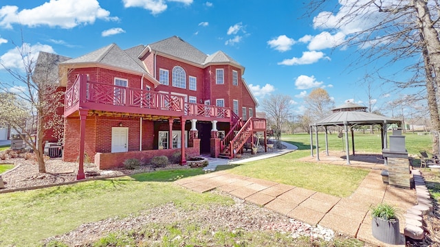 back of house featuring a lawn, a gazebo, cooling unit, a wooden deck, and brick siding