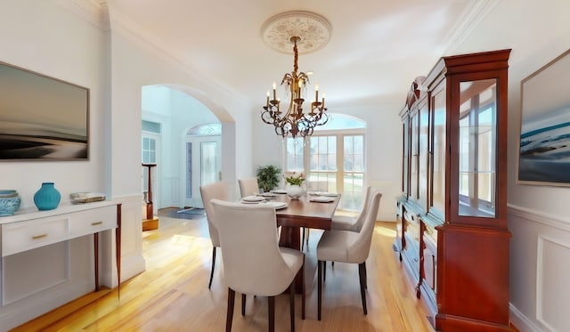 dining room with a healthy amount of sunlight, an inviting chandelier, and light hardwood / wood-style floors