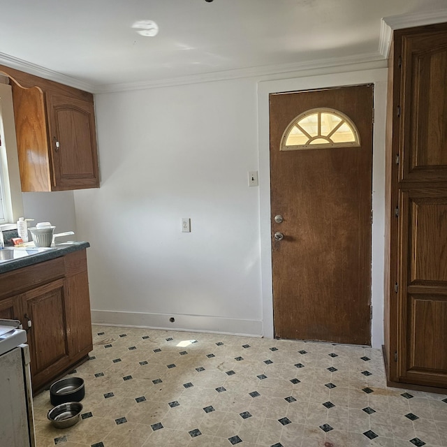 foyer entrance with light floors, baseboards, and crown molding