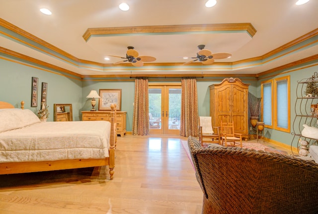 bedroom featuring french doors, a tray ceiling, light hardwood / wood-style floors, and ornamental molding