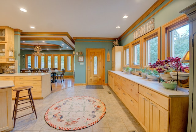 kitchen featuring kitchen peninsula, a kitchen bar, a healthy amount of sunlight, and ornamental molding