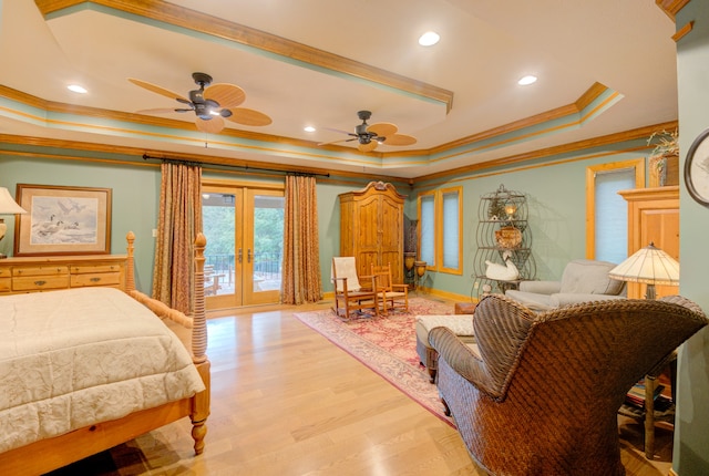 bedroom featuring light hardwood / wood-style floors, french doors, crown molding, a raised ceiling, and access to outside