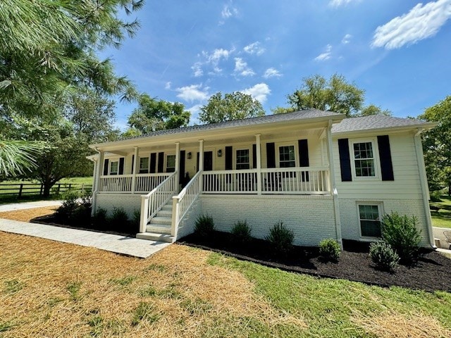 view of front of house with a front yard and a porch