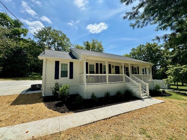 single story home with central air condition unit and covered porch