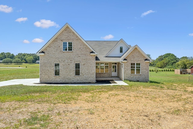 back of property with a lawn and brick siding