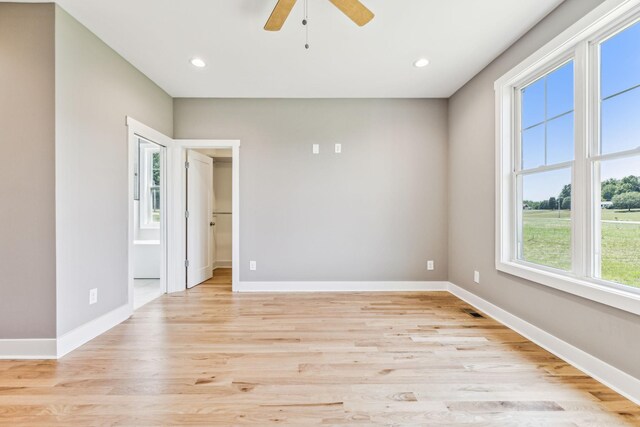 spare room with ceiling fan and light wood-type flooring