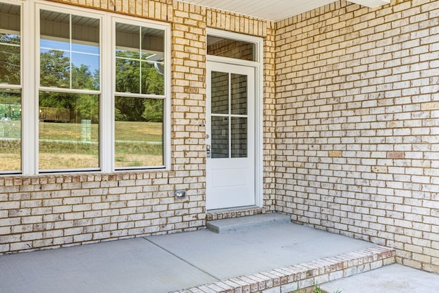 entrance to property featuring brick siding