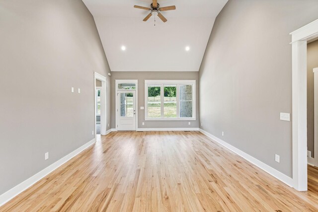 unfurnished living room with light hardwood / wood-style floors, high vaulted ceiling, and ceiling fan