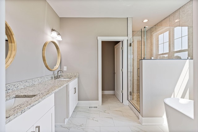 bathroom with marble finish floor, a stall shower, a sink, and baseboards