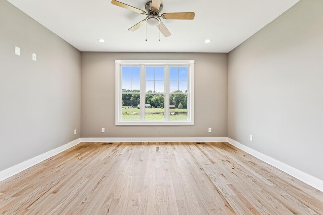 spare room with ceiling fan and light wood-type flooring