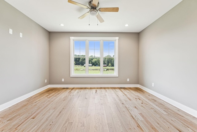 empty room with light wood finished floors, recessed lighting, a ceiling fan, and baseboards