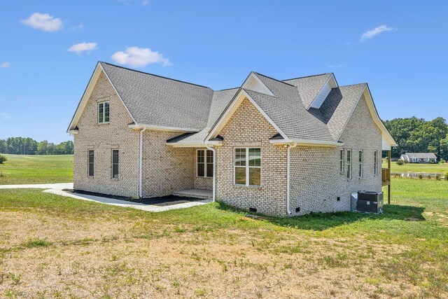 exterior space featuring cooling unit and a lawn