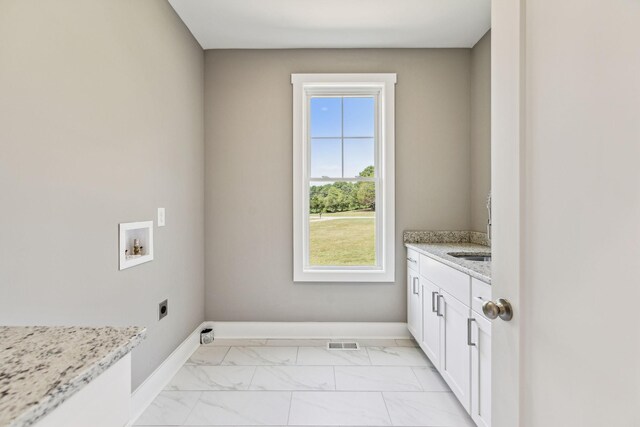 clothes washing area with cabinets, hookup for a washing machine, and electric dryer hookup