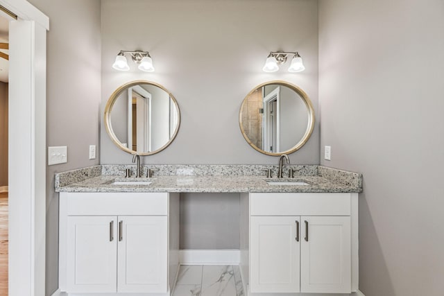 full bathroom featuring double vanity, marble finish floor, and a sink