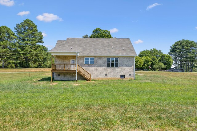 rear view of house with a lawn and a wooden deck