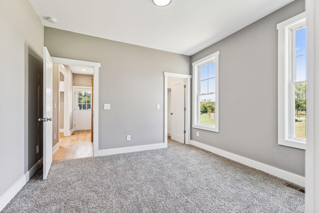 unfurnished bedroom with multiple windows and light colored carpet