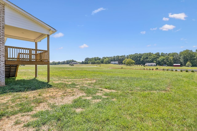 view of yard with a rural view and a wooden deck