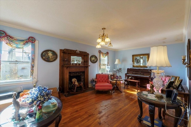 living room featuring hardwood / wood-style floors, an inviting chandelier, ornamental molding, a fireplace, and a textured ceiling