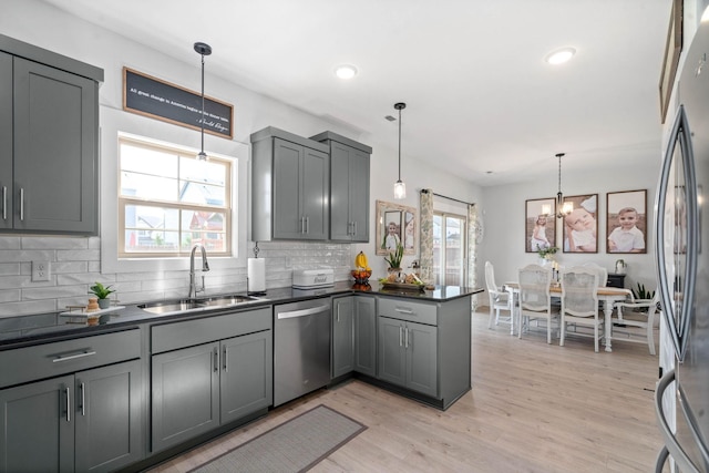 kitchen featuring gray cabinets, sink, stainless steel appliances, and hanging light fixtures