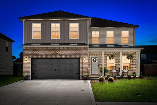 front facade featuring a lawn, a porch, and a garage