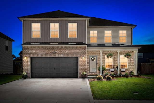 front facade featuring a garage and a yard