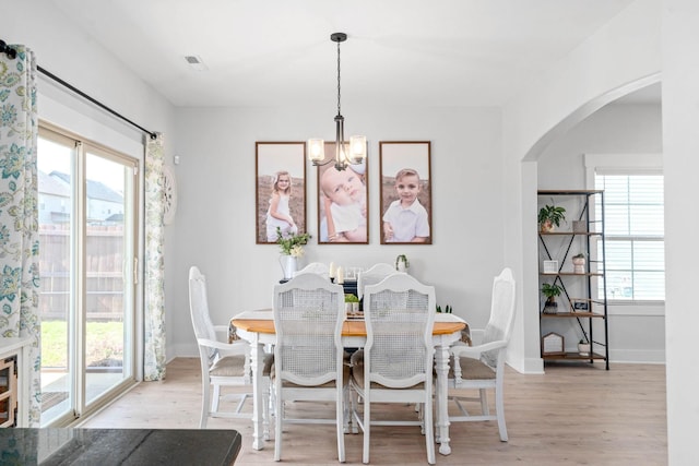 dining room featuring light wood-type flooring and a notable chandelier