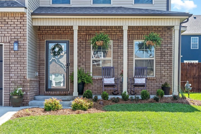 doorway to property featuring a lawn and covered porch