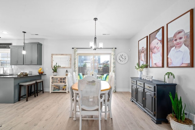 dining area featuring light hardwood / wood-style floors and a chandelier