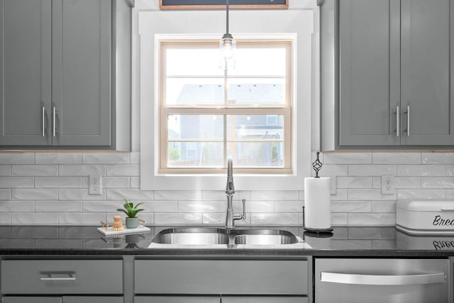 kitchen with gray cabinetry, sink, dishwasher, and decorative backsplash