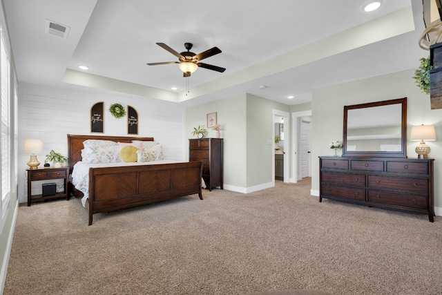 bedroom featuring light colored carpet, ceiling fan, and a raised ceiling