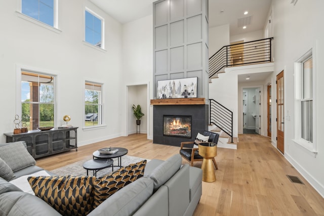 living room featuring a high ceiling and light hardwood / wood-style flooring