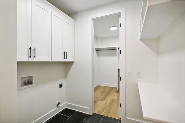 washroom with dark wood-type flooring, hookup for a washing machine, cabinets, and hookup for an electric dryer