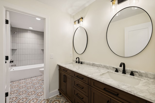 full bathroom featuring tile patterned flooring, toilet, dual vanity, and tiled shower / bath