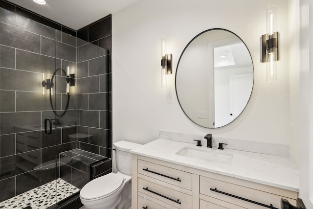 bathroom featuring toilet, a shower with door, and vanity