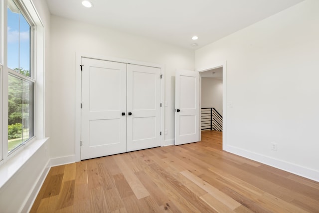 unfurnished bedroom with a closet and light hardwood / wood-style floors