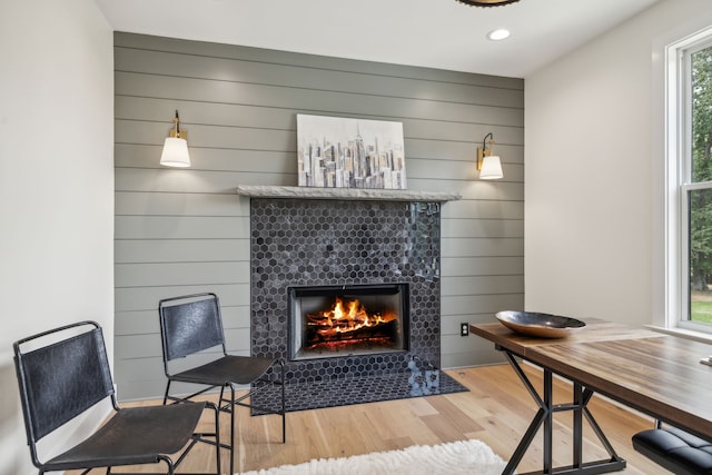 interior space featuring plenty of natural light, light wood-type flooring, and a tile fireplace