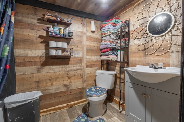 bathroom with toilet, wooden walls, wooden ceiling, and vanity