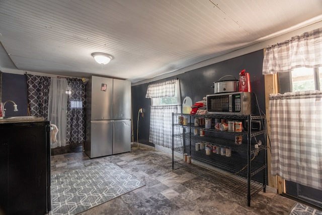 interior space with sink, stainless steel refrigerator, and tile patterned floors