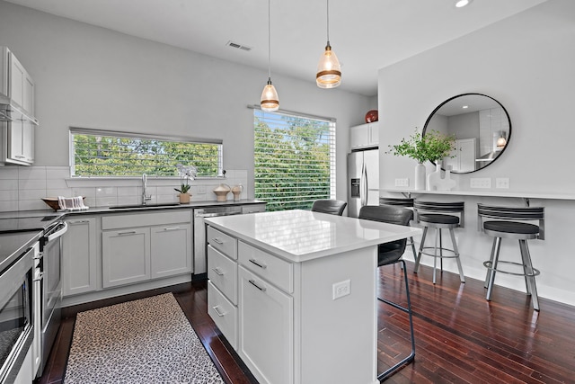 kitchen featuring sink, decorative backsplash, a center island, and dark hardwood / wood-style floors