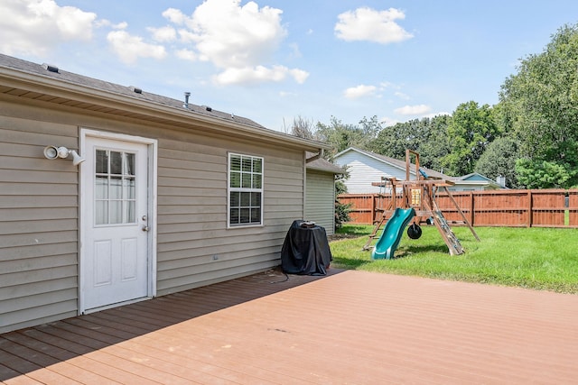 deck featuring a playground and a yard