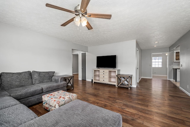 living room featuring a textured ceiling, ceiling fan, and dark hardwood / wood-style flooring