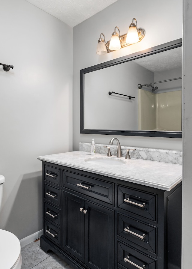 bathroom featuring tile patterned flooring, toilet, and vanity