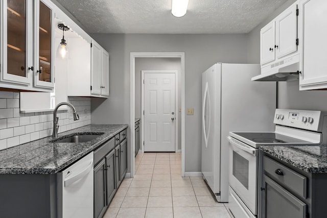 kitchen with decorative light fixtures, sink, white cabinets, light tile patterned floors, and white appliances