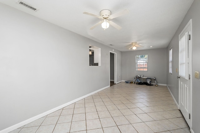 tiled empty room featuring ceiling fan