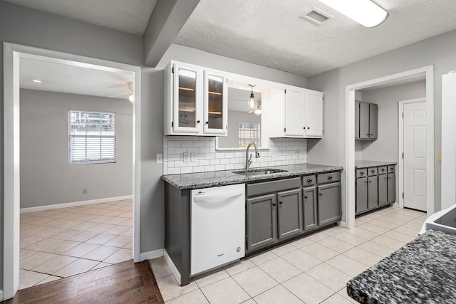 kitchen with dishwasher, tasteful backsplash, sink, light tile patterned flooring, and gray cabinets